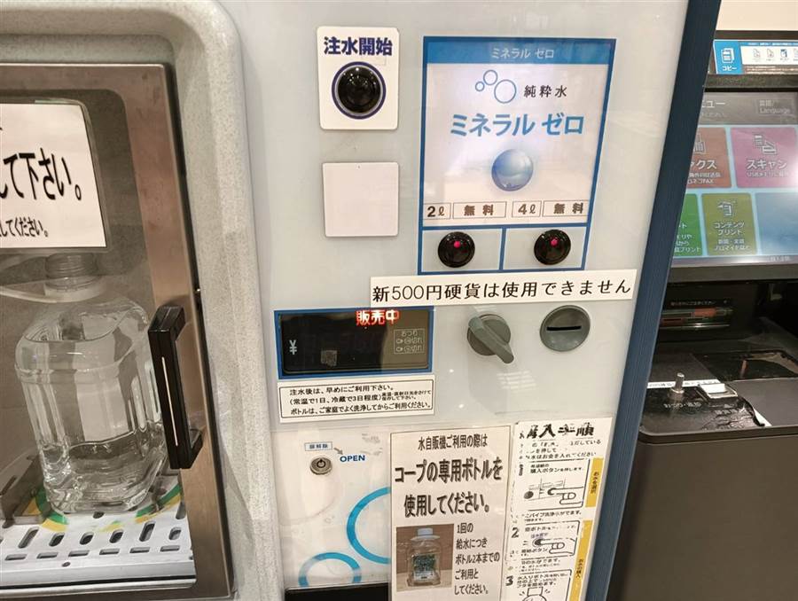 給水機の操作パネル。注水開始ボタンとミネラルゼロ純粋水の2ℓ・4ℓ無料ボタン、硬貨投入口